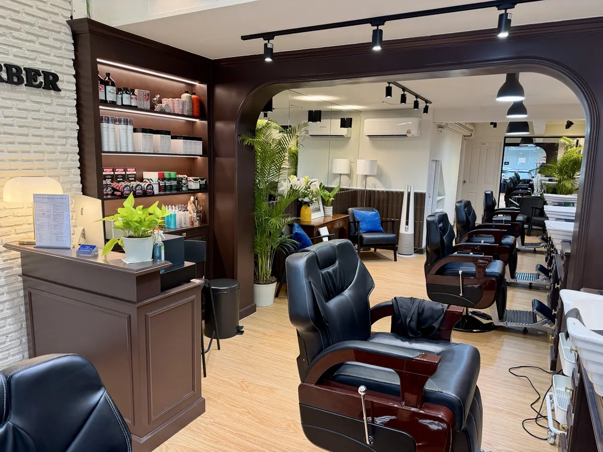 Wide view of the barber chairs, reception and interior at The Standard Barber Bangkok